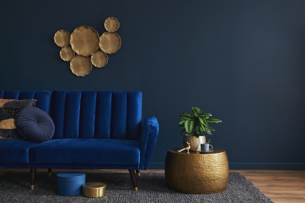 Salon avec un canapé de couleur bleu roi et des éléments de décoration de couleur or
