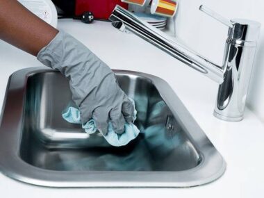 Aide-ménagère nettoyant un evier de cuisine
