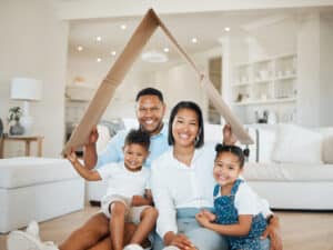 Famille avec un toit en carton au dessus de leurs tetes symbolisant la protection
