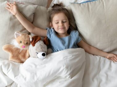 Petite fille dormant dans son mit avec le sourire