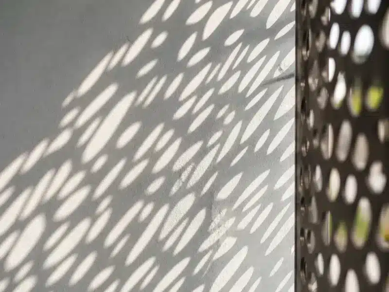 Ombre portée sur un mur par un élement en metal découpé au laser